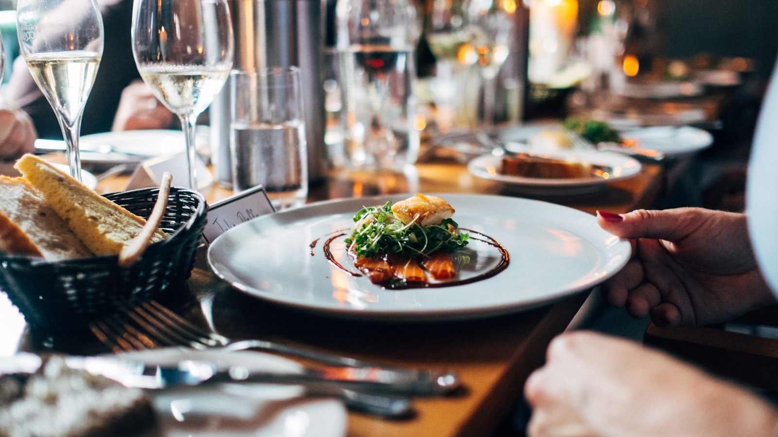 A beautifully plated dish served at a lively, candlelit restaurant table